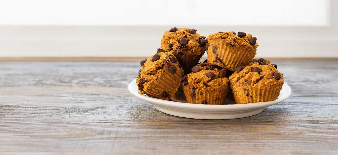 Chocolate Pumpkin Muffins piled high on a white plate