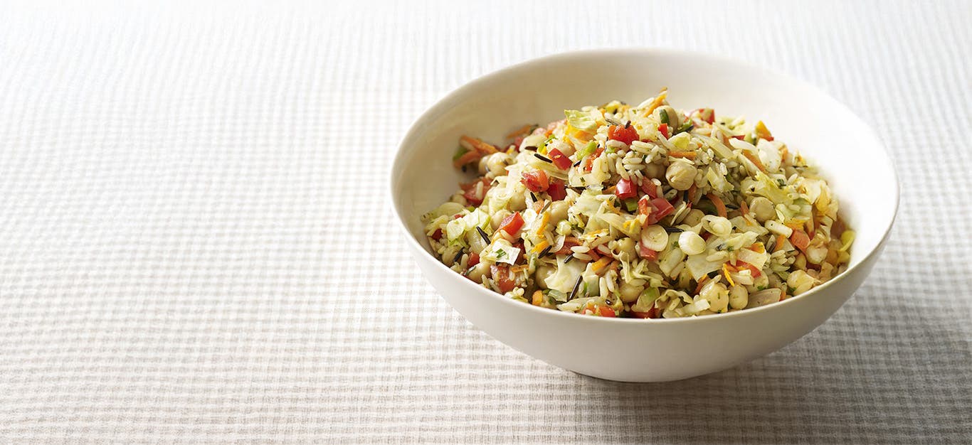 Wild Rice, Cabbage and Chickpea Pilaf in a white bowl on a pale checkered table cloth