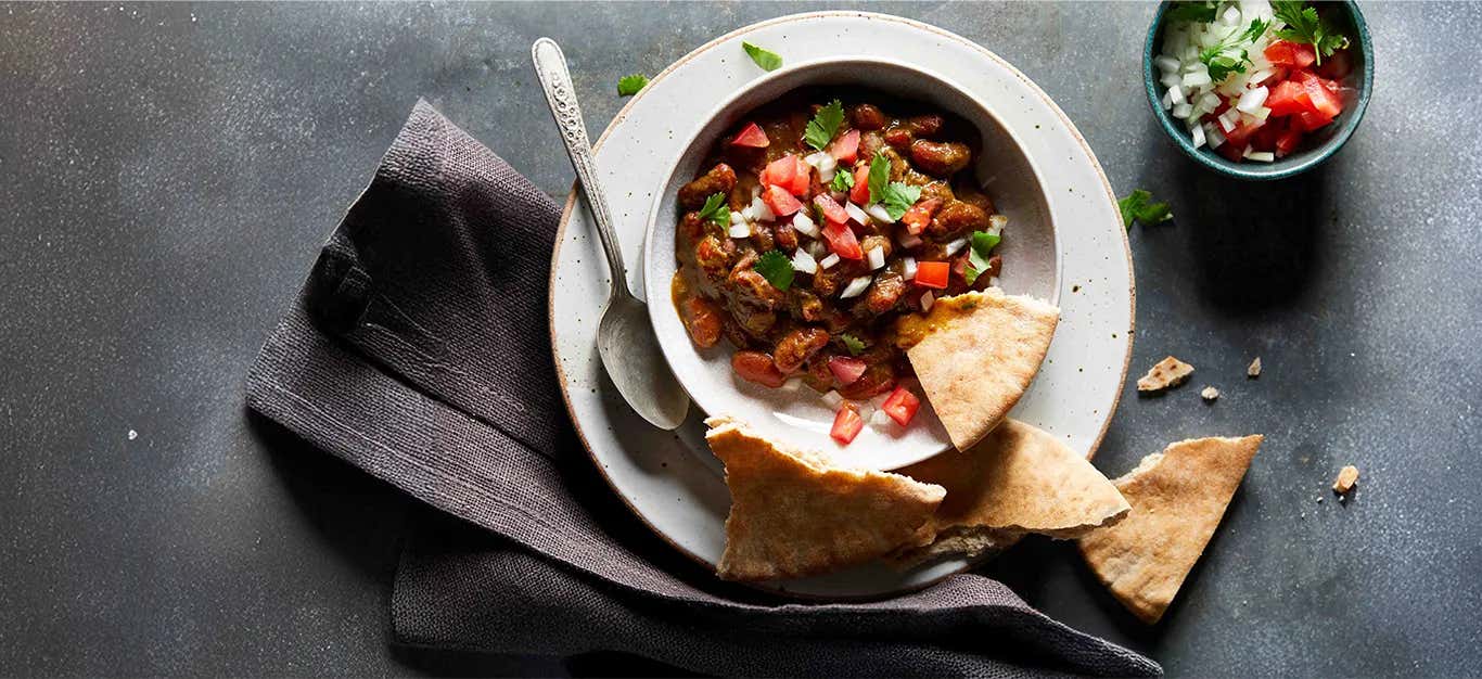Instant Pot Kidney Bean Dal in a white bowl with pita squares on the side