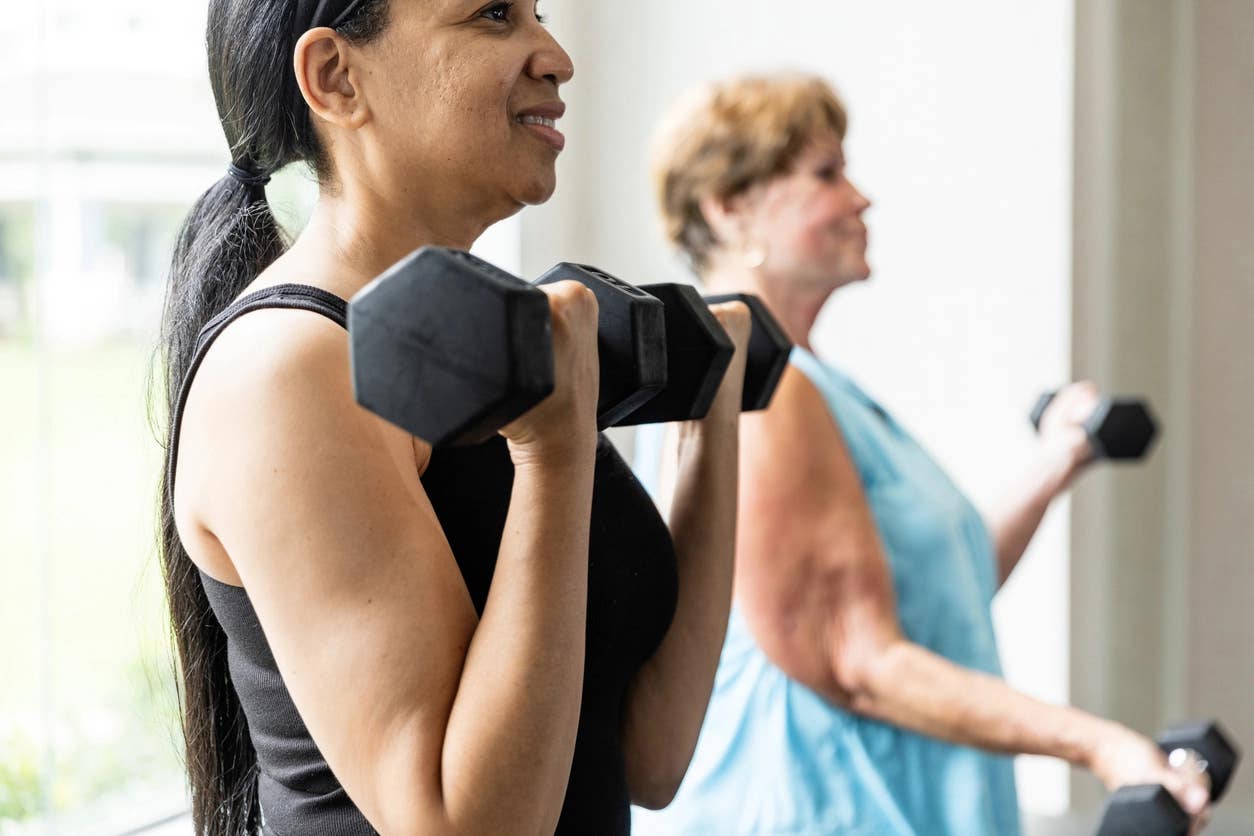A middle-aged woman and senior woman lifting weights in a gym