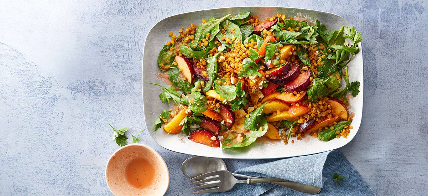 Plum Spinach Salad with Lentils on a large white platter