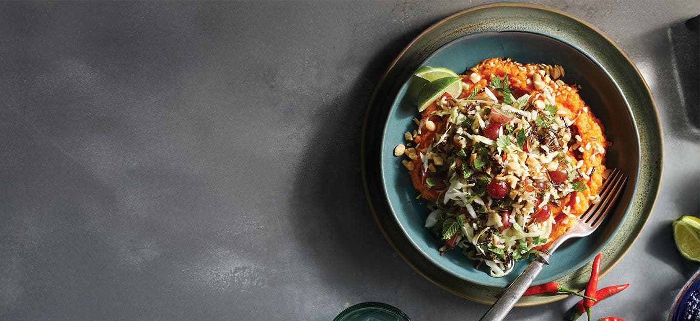 A bowl of Spicy Thai Cabbage and Rice Salad on a dark grey background