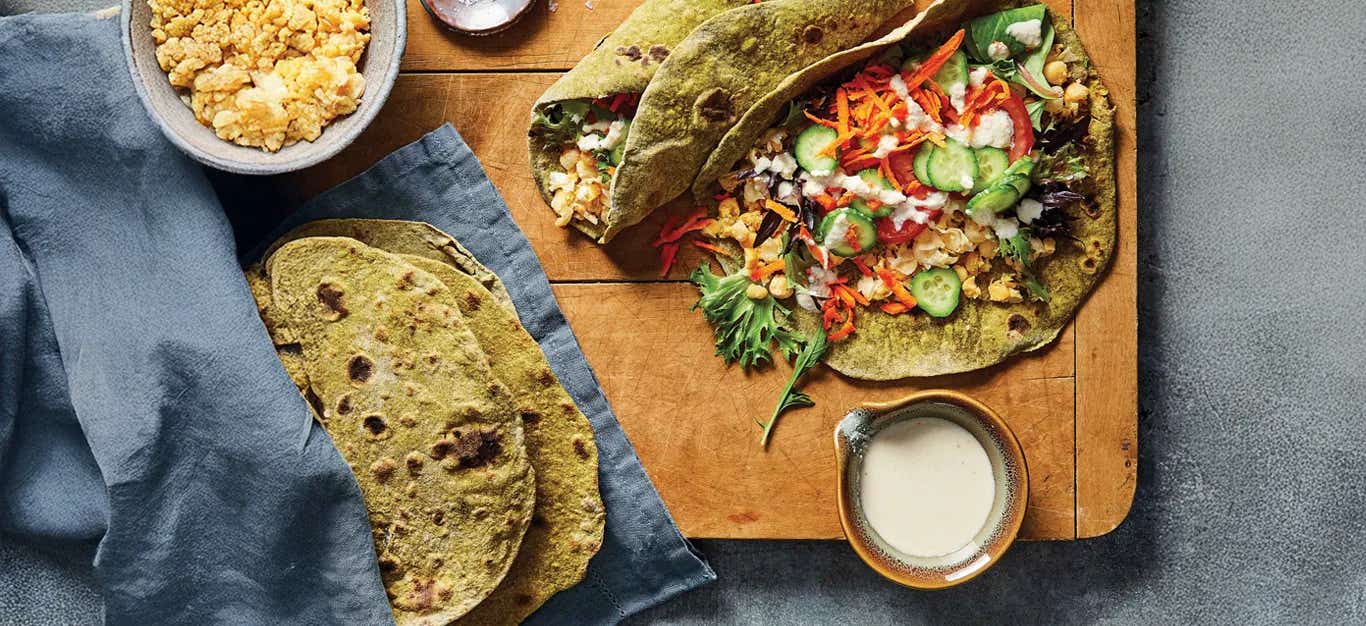 Chickpea Wraps with Homemade Spinach Tortillas on a wood tabletop