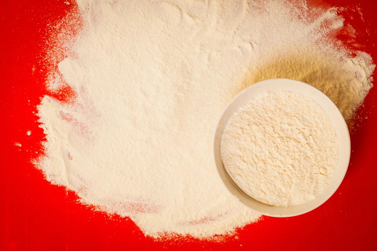 whole-grain gluten-free flour in a bowl and spread next to the bowl on a red background