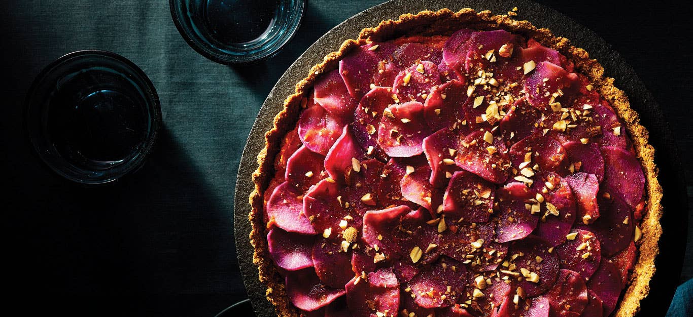 Sweet Potato Rosette Tart on a grey cake stand against a dark blue tablecloth