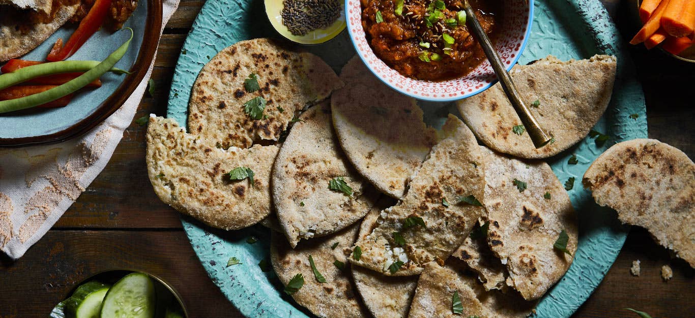 Cauliflower Parathas served on a turquoise plate with small bowl of tomato chutney