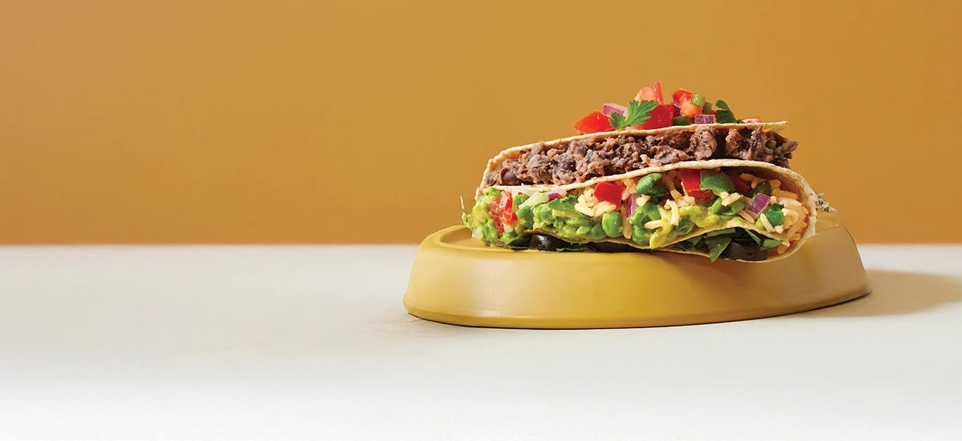 A Fold-Up Rice and Black Bean Quesadillas on an upturned plate against a mustard background