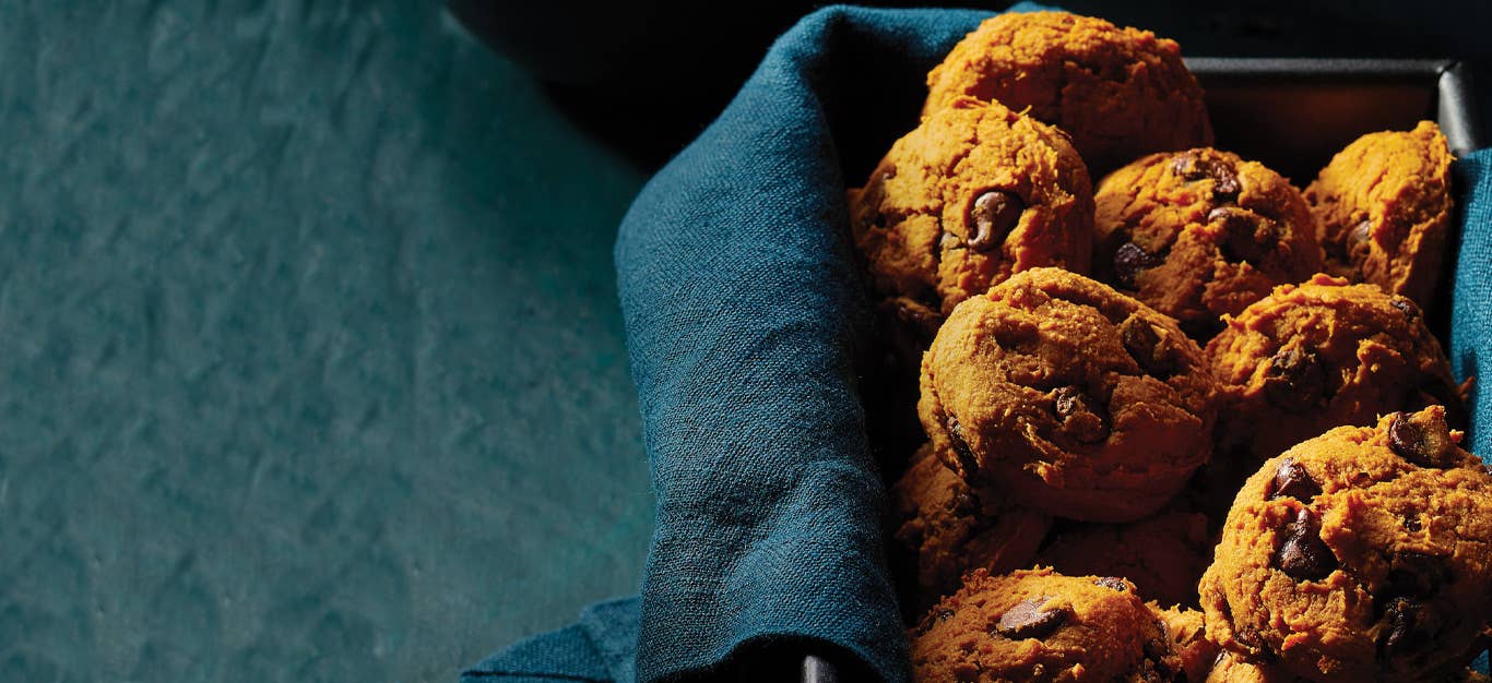 Sweet Potato Chocolate Chip Cookies resting in a dark blue cloth in a rectangular baking tin