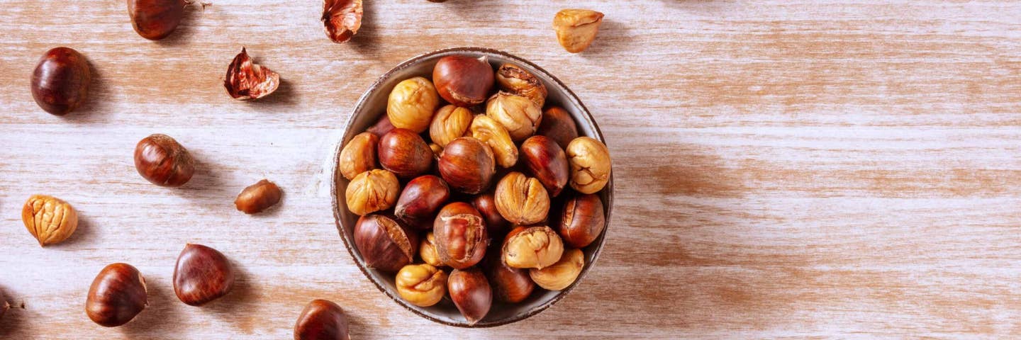 a bowl of chestnuts, some peeled so just the inner nuts remain, some with the outer layer intact