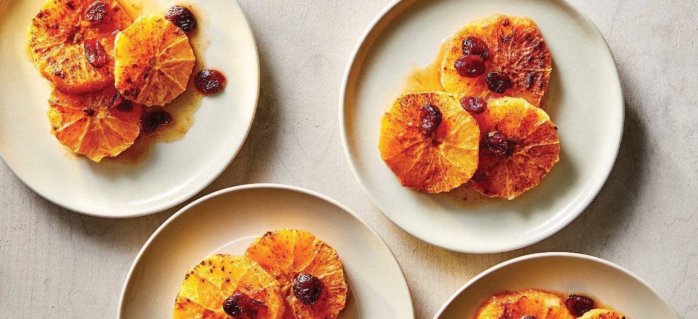 Spiced Roasted Oranges with Dried Cranberries on white plates