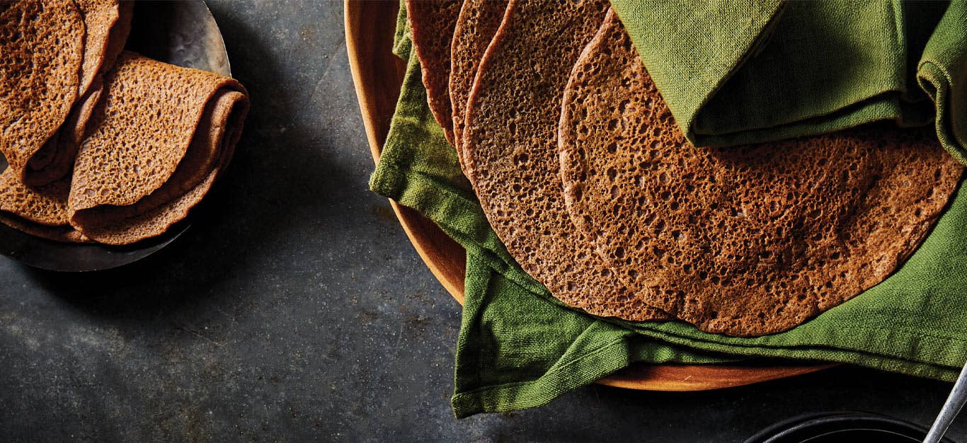 Quick and Easy Injera resting in green cloth napkins
