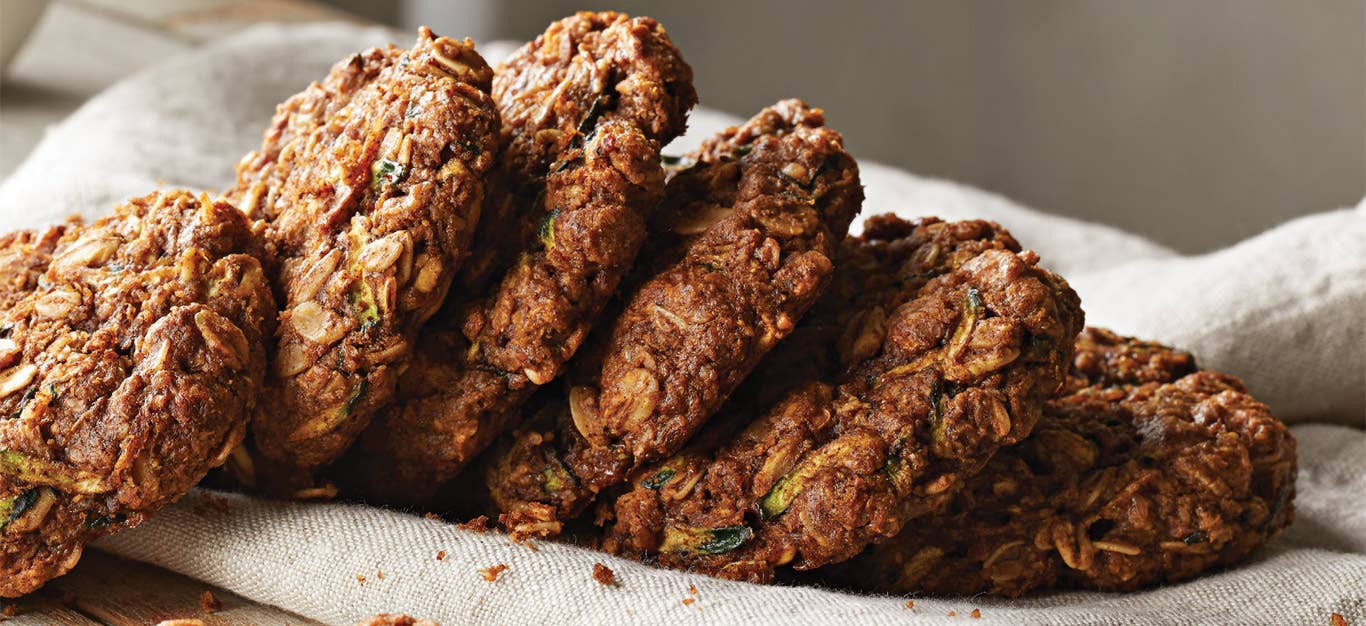 Dreamy Zucchini Breakfast Cookies stacked in a row on a white kitchen towel