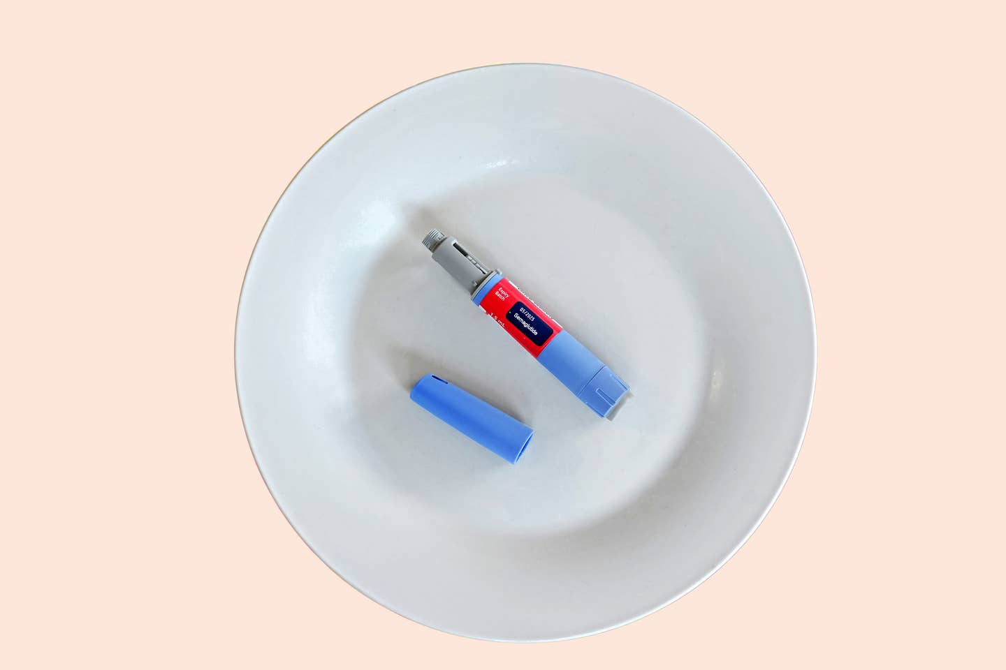 An injectable dose of semaglutide, the drug known as Ozempic and Wegovy, on a plain white plate