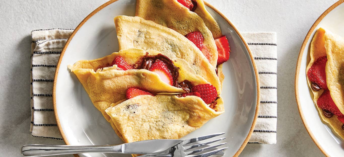 Gluten-Free Crepes stuffed with strawberries on a white ceramic plate