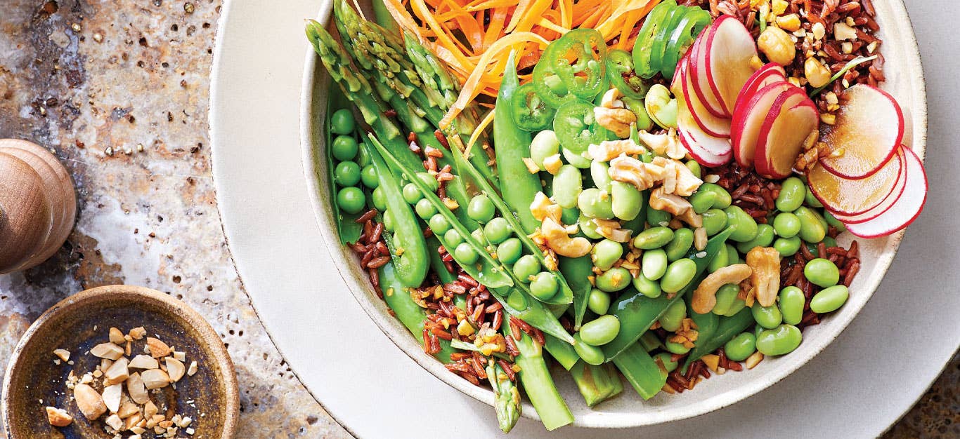Red Rice and Edamame Bowl with Spring Veggies in a white ceramic dish