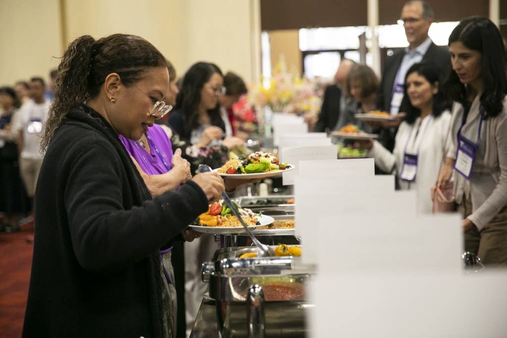 Attendees of the Plant-Based Nutrition Healthcare Conference serve themselves whole food plant based lunch at a buffet