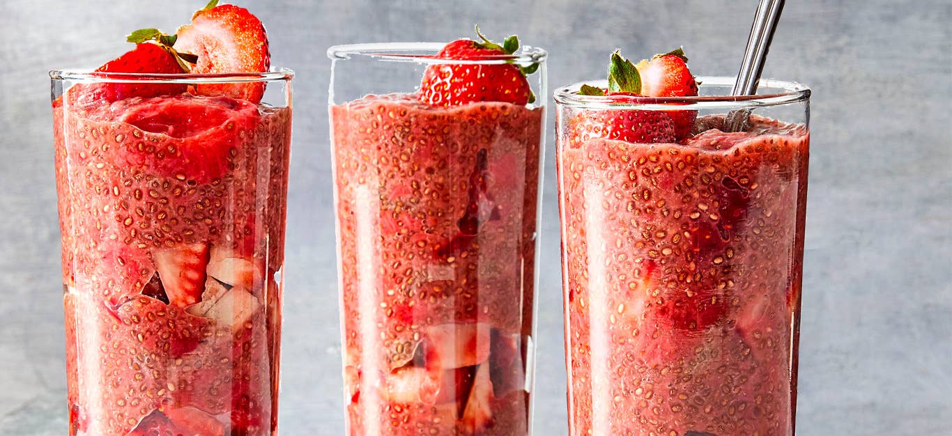 Strawberry Chia Seed Pudding in tall parfait glasses against a gray background