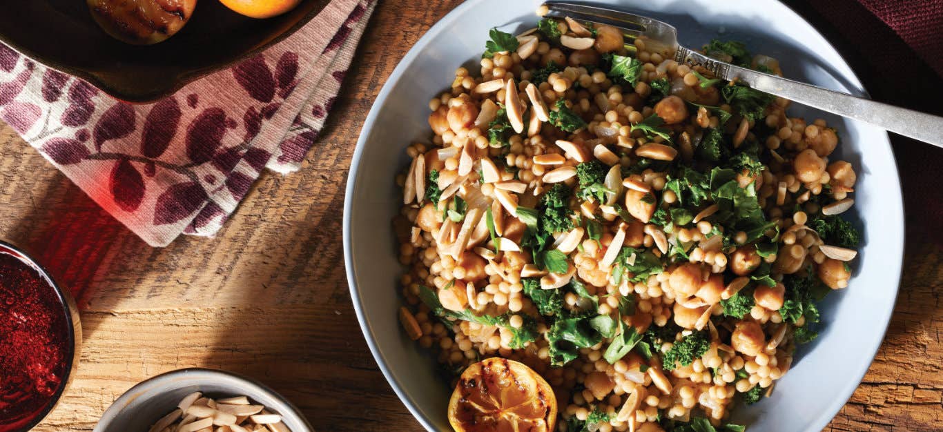 Za'atar-Seasoned Couscous with Kale and Charred Lemon in a wide-rimmed serving bowl with a fork