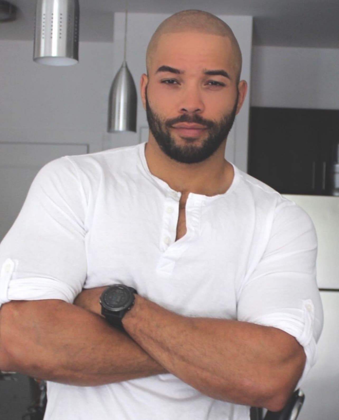 headshot of Dominick Thompson wearing a white shirt with arms folded in a kitchen