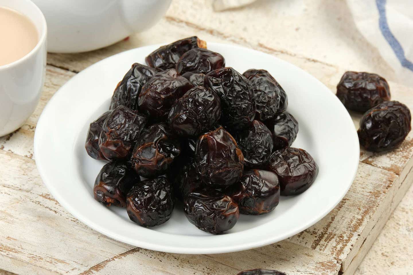 a pile of dark ajwa dates on a white plate