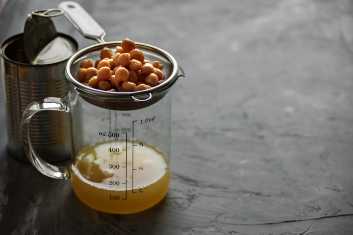 aquafaba being strained out of a can of chickpeas for a vegan egg substitute