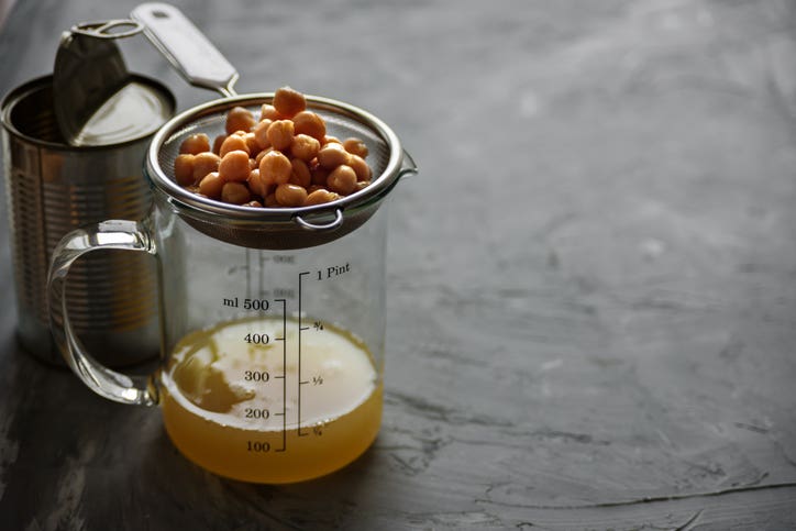 aquafaba being strained out of a can of chickpeas for a vegan egg substitute