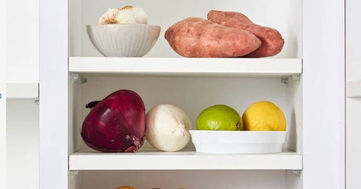 Garlic, potatoes, red onion, white onion, lemon, and lime in a pantry