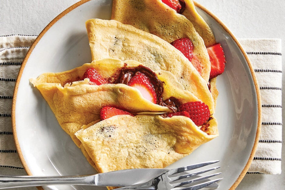 Gluten-Free Crepes stuffed with strawberries on a white ceramic plate
