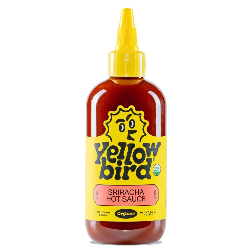 Bottle of YellowBird sriracha hot sauce on a white background