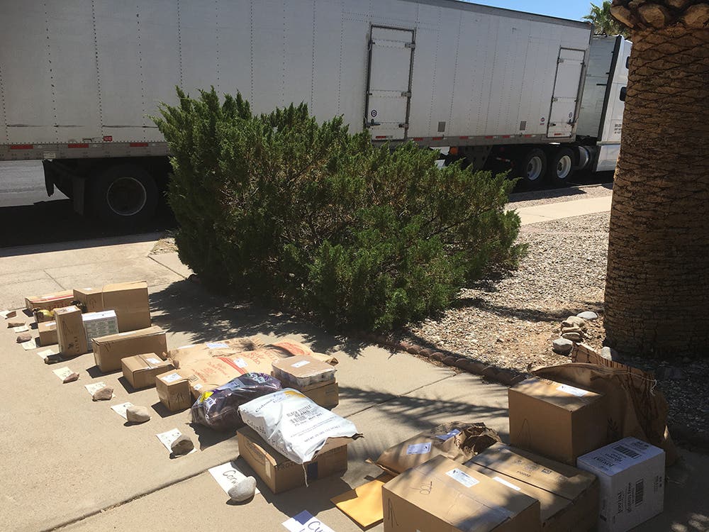 Azure Standard truck on a neighborhood street with order laid out in front ready for people to pick up