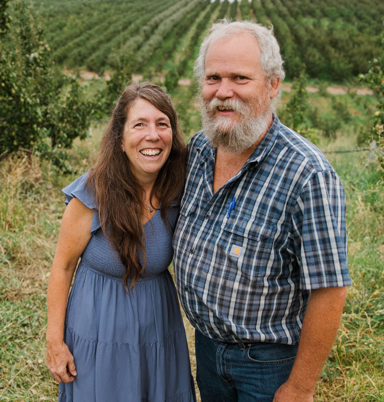 David and Kimberly Stelzer from Azure standing on a hill with a field of produce behind them 