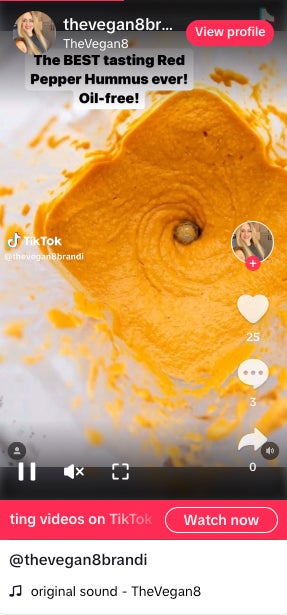 Screenshot of a TikTok video by Brandi Doming of TheVegan8 - the screenshot shows an oil-free red pepper hummus in a blender