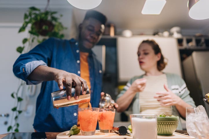 Friends preparing shaken mocktail recipes at home