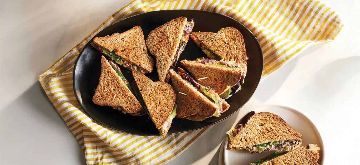 A plate of Hummus Salad Sandwiches cut in half diagonally