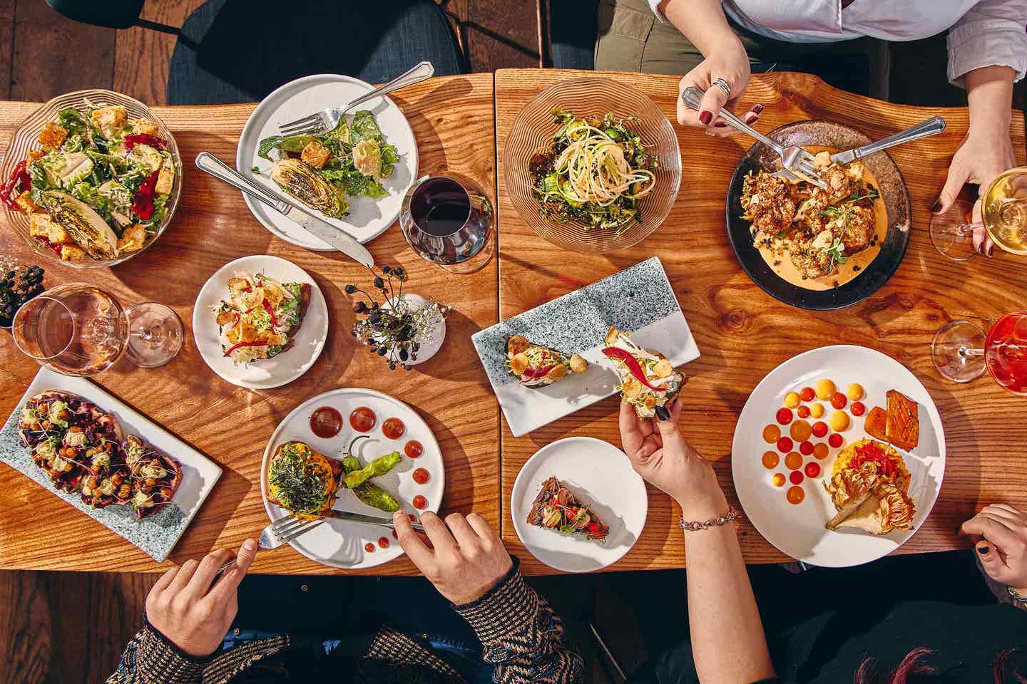 A top-down shot of a spread of vibrant plant-based dishes at upscale NYC vegan restaurant Avant Garden