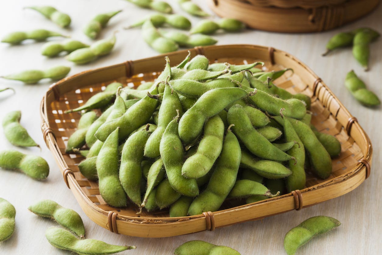 edamame-in-a-bamboo-woven-basket A pile of fresh or steamed edamame in a woven bamboo tray