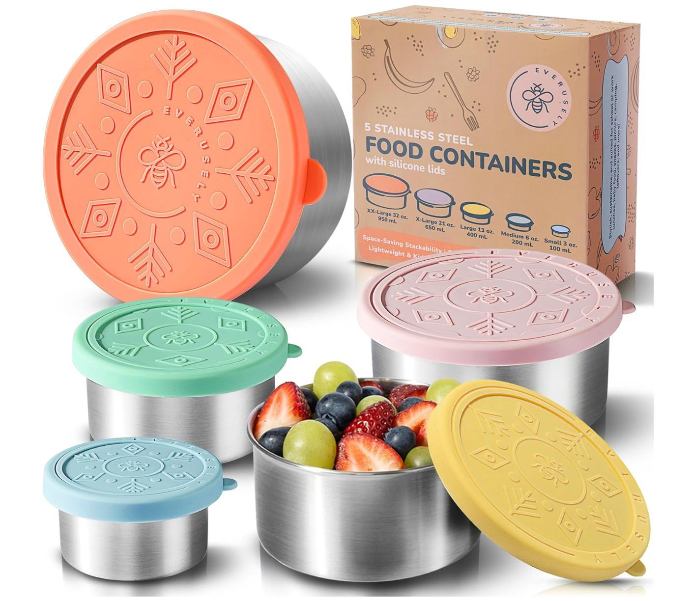 A set of 5 stainless steel food containers with fresh grapes and berries in one of the containers. They all have different pastel-colored lids