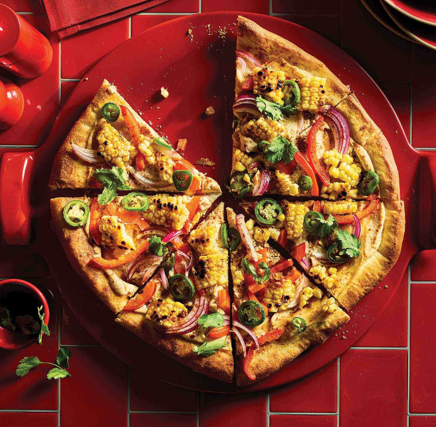 Red Emile Henry Pizza Stone topped with a wholesome homemade vegan pizza
