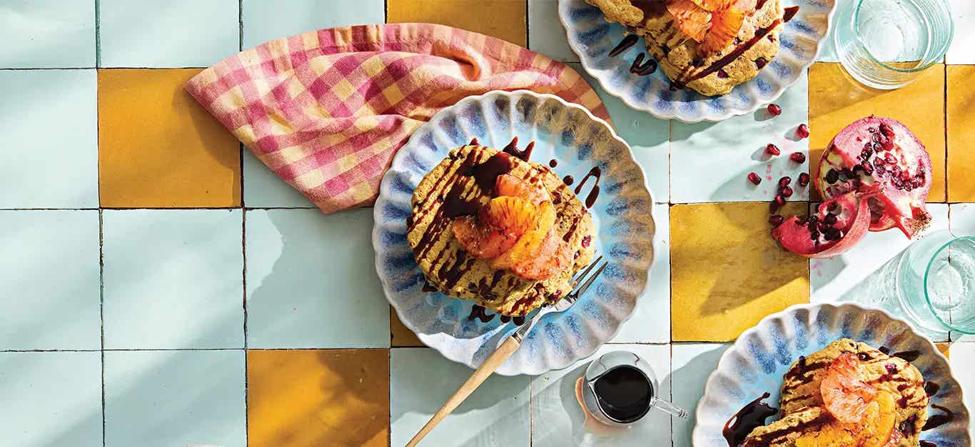 A plate of Pomegranate Pancakes with grapefruit and orange