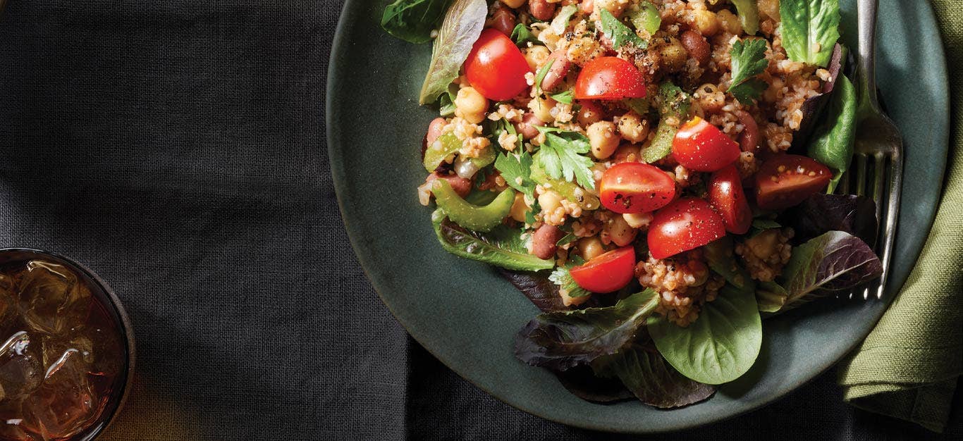 Bulgur-Bean Salad with Tomato Vinaigrette on a gray ceramic plate with a green cloth napkin