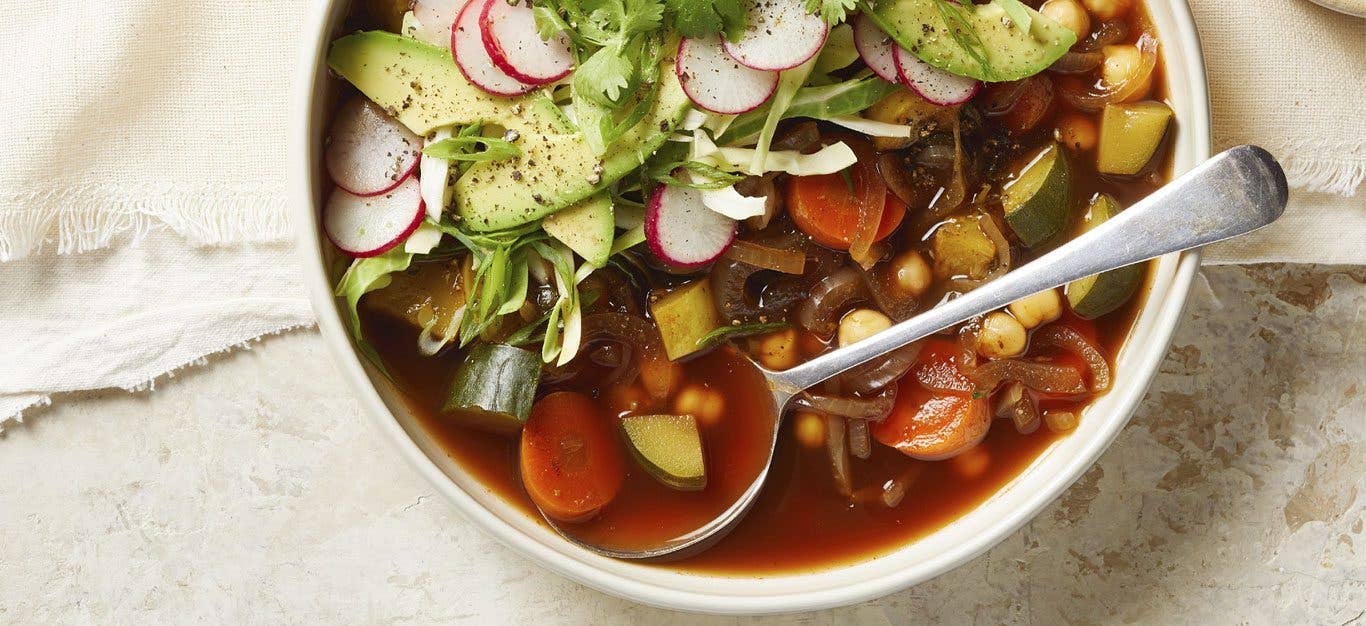 30-Minute Chickpea Pozole in a white bowl with a metal spoon