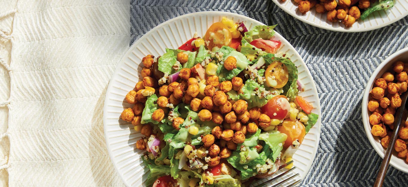 Chopped Salad with Air-Fried BBQ Chickpeas on a white plate against a herringbone pattern tablecloth