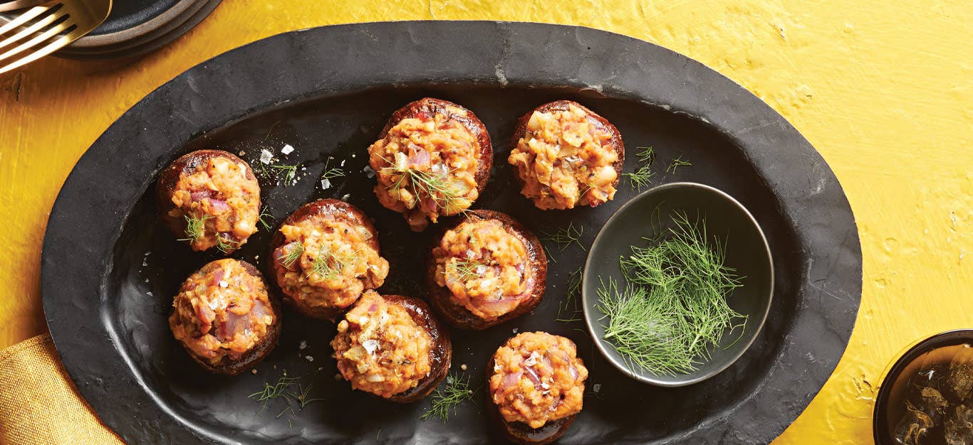Smoky Vegan Stuffed Mushrooms on a slate serving tray against a yellow background