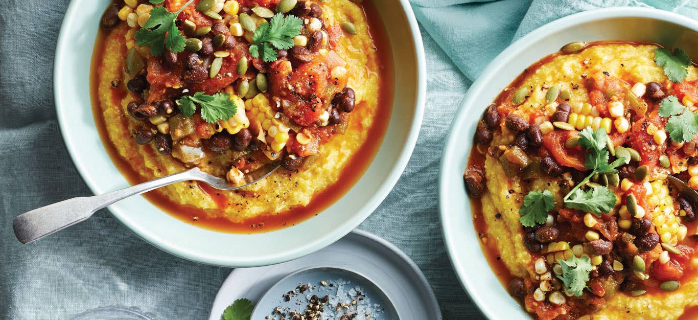 Creamy Polenta with Jalapeño Tomato Sauce in light blue ceramic bowls against a blue fabric background