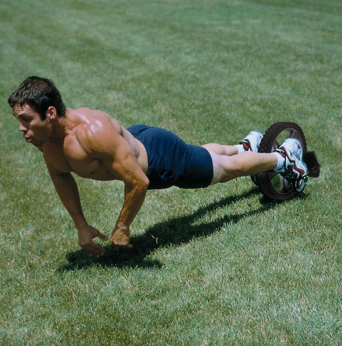 bare chested man using power wheel outside on the grass