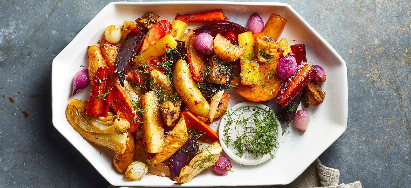 Roasted Root Vegetable Medley on a white serving platter with a side of dipping sauce