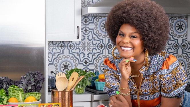 Photo of Tabitha Brown in a kitchen, smiling