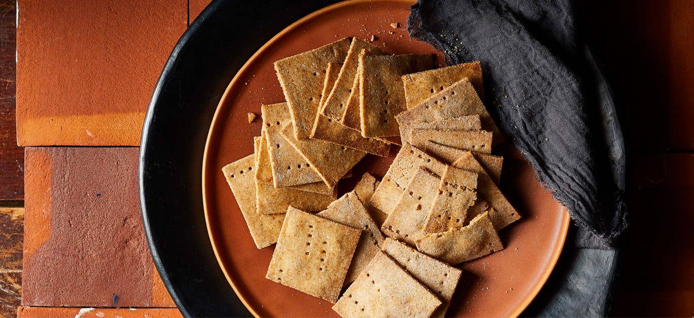 Vegan Cheesy Crackers on a brown plate next to a gray cloth napkin