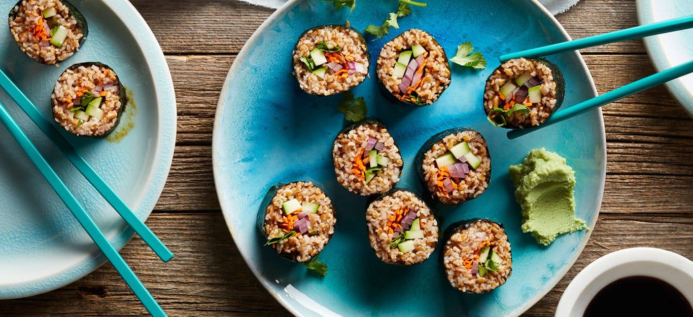 Bulgur Sushi with Zucchini - Held with chopsticks, with a dab of wasabi on the side