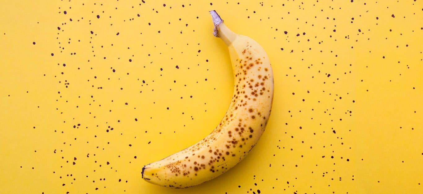 A ripe banana on a yellow background with spots - recipes for ripe and overripe bananas